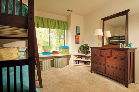 A bedroom with a bunk bed and a dresser.