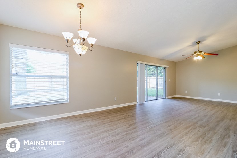 an empty living room with a wood floor and a window