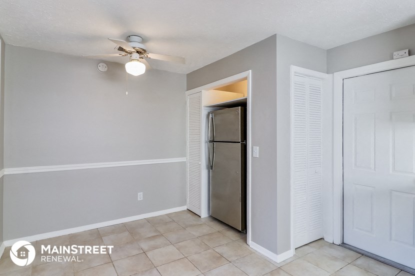 a living room with a ceiling fan and a closet