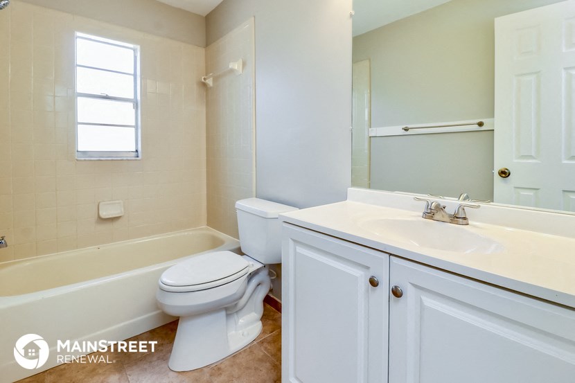 a bathroom with a toilet and a sink and a bath tub