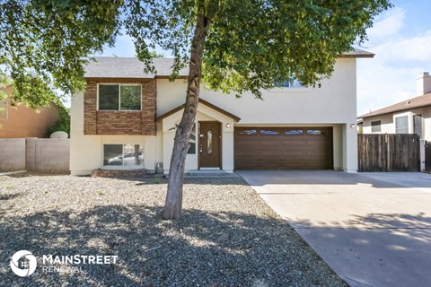 a house with a garage and a tree in front of it