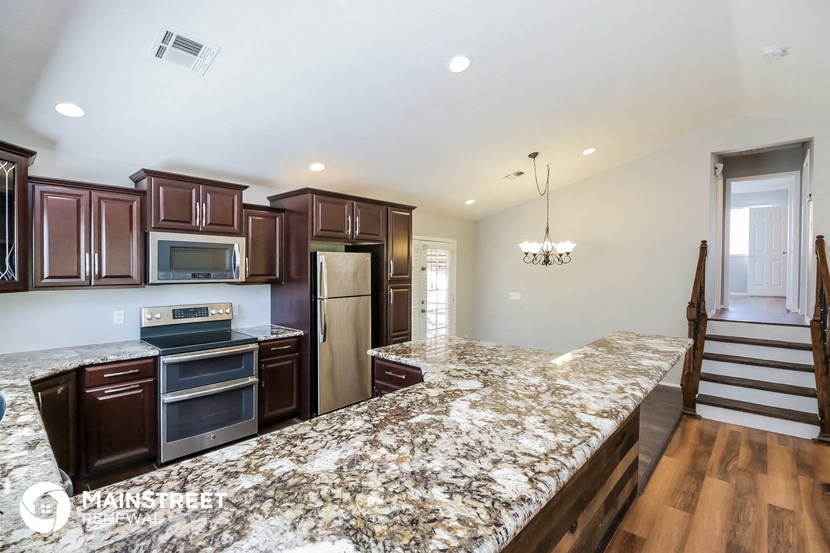 a kitchen with a large island with a granite counter top