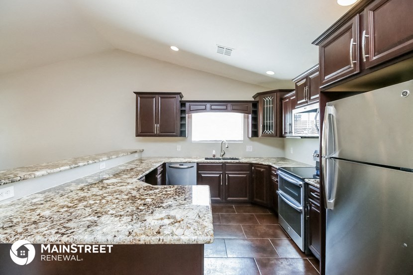 the kitchen has stainless steel appliances and granite counter tops