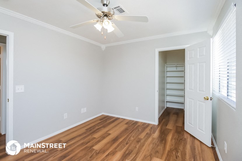 the living room with wood flooring and a ceiling fan