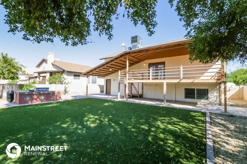 a backyard with a lawn and a house with a deck