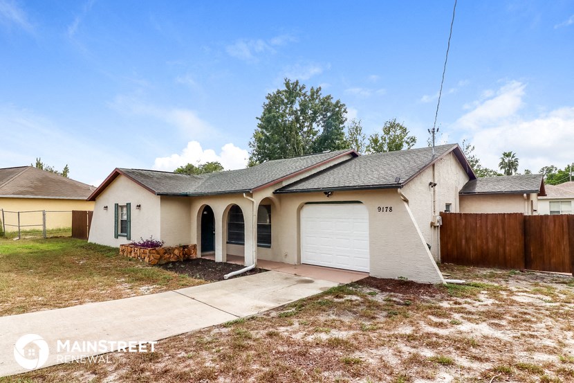 a beige house with a garage and a yard