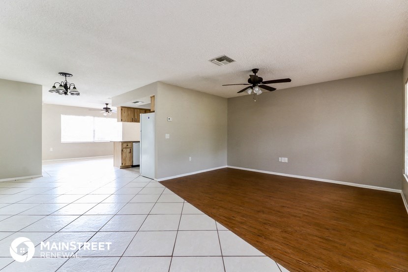 an empty living room with a ceiling fan
