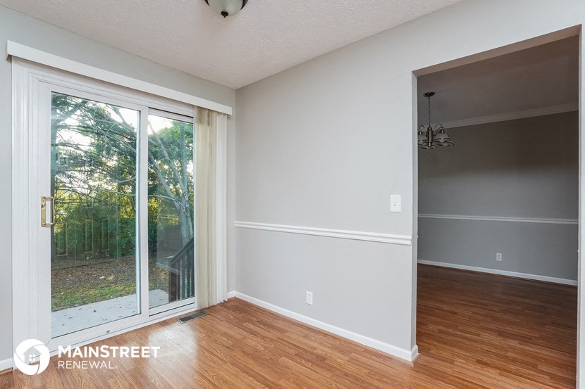 the living room of an empty house with wood floors and a sliding glass door