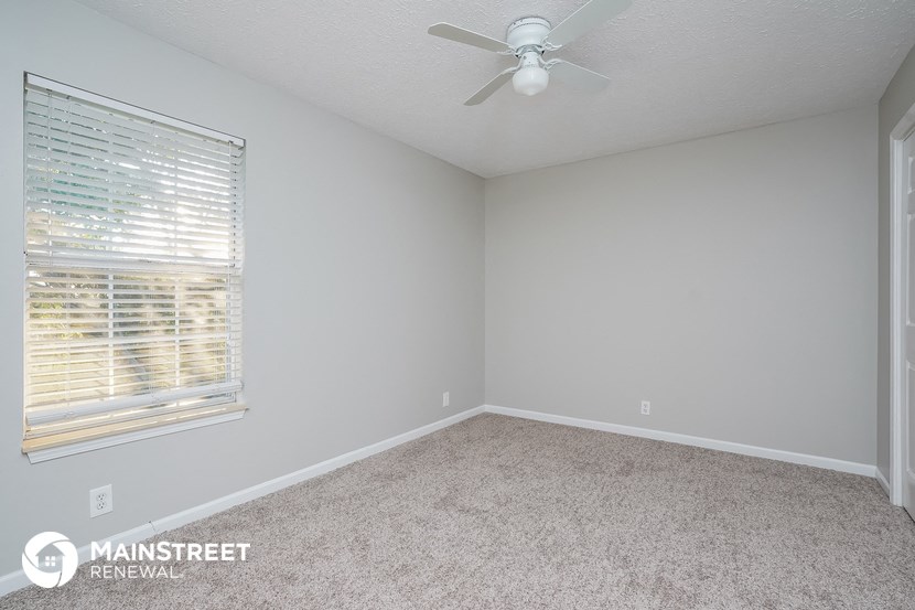 a bedroom with a ceiling fan and a window