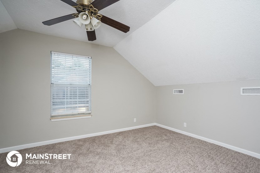 a bedroom with a ceiling fan and a window