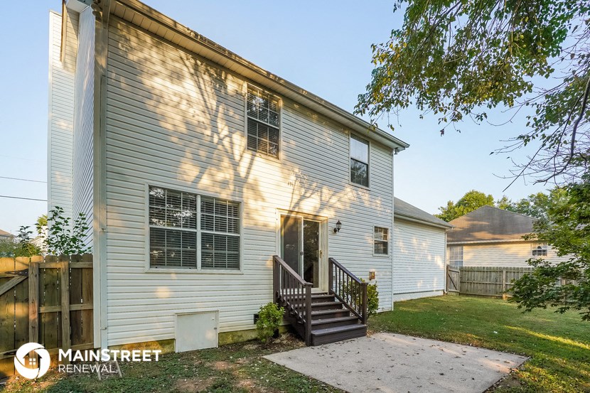 the outside of a white house with a porch and stairs