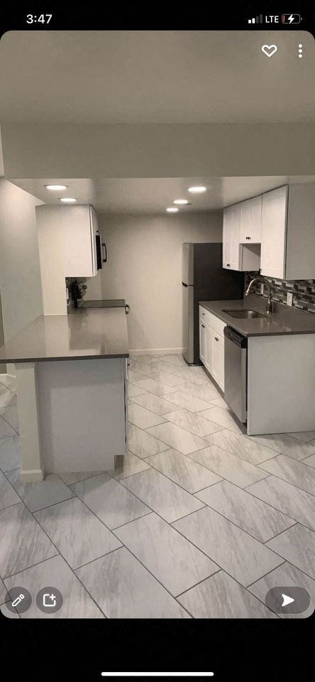 an empty kitchen with white cabinets and a sink