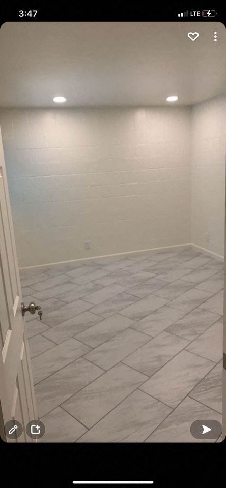 a bathroom with a tiled floor and a white wall