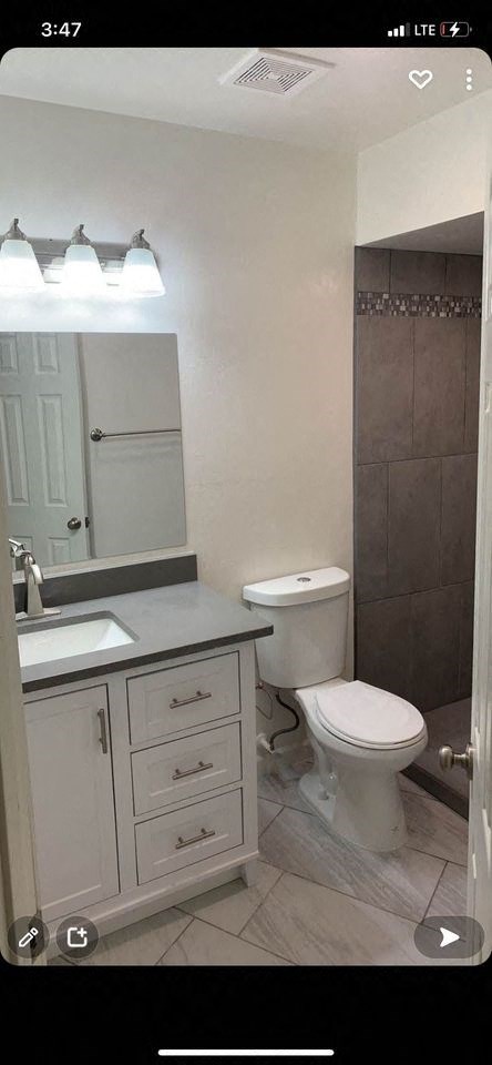 a bathroom with a toilet and a sink and a mirror