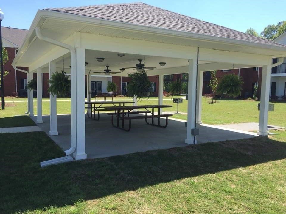 a patio with a table and chairs under a pavilion