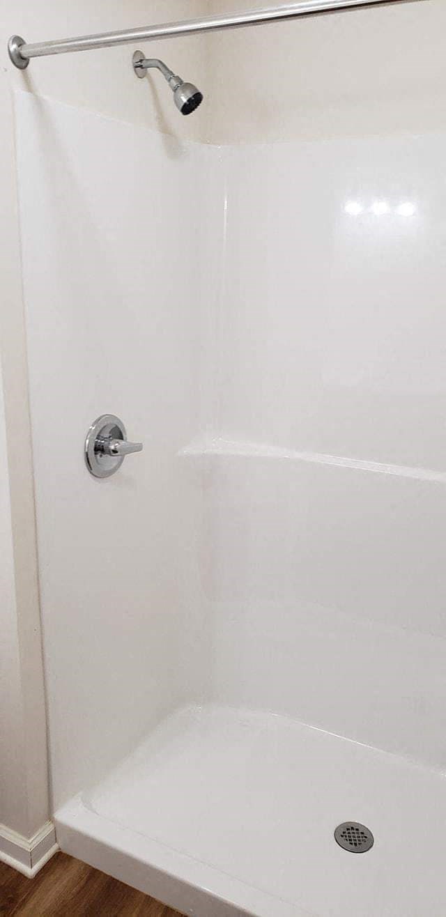 a white shower in a bathroom with a shower curtain