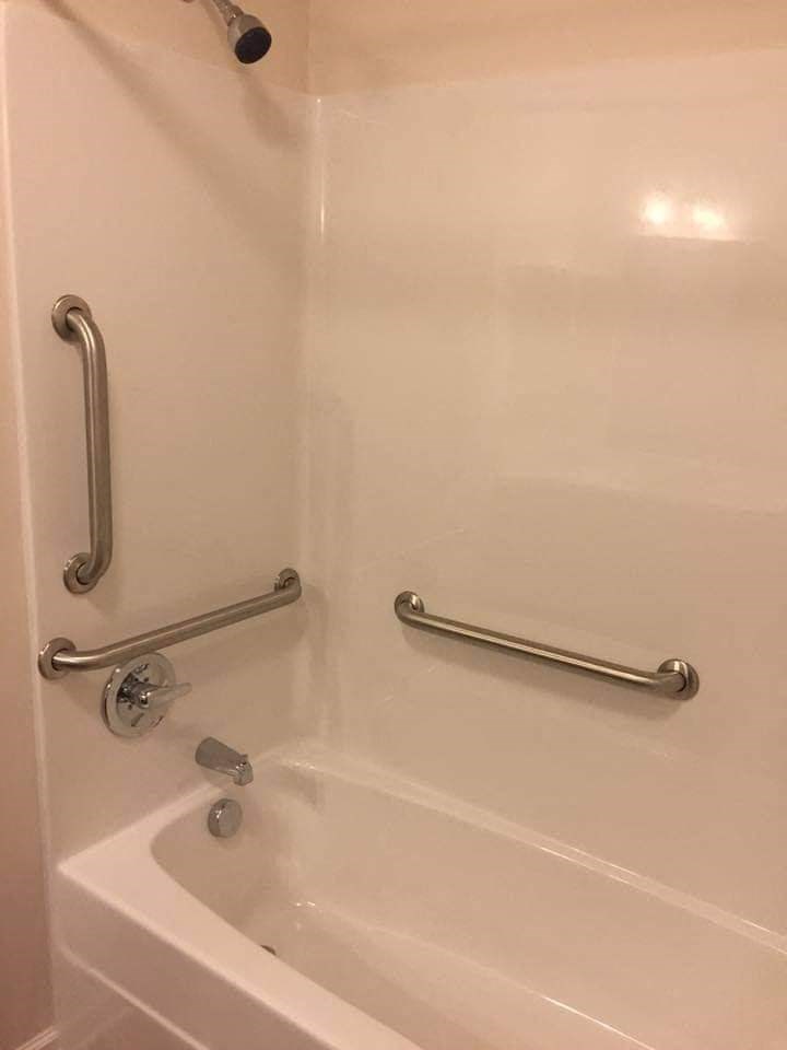 a bathroom with a bath tub and grab bars