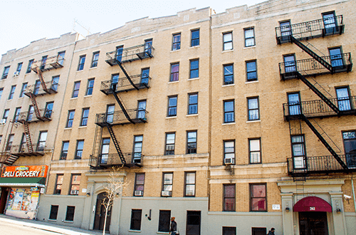 a large brick building with many windows and fire escapes