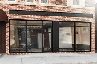 a brick storefront with glass windows and a black facade