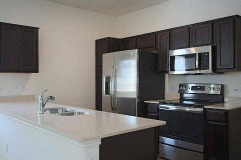 A kitchen with black cabinets and stainless steel appliances.