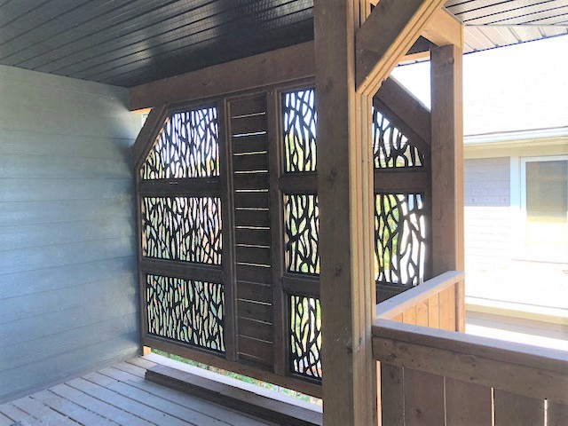 a porch with a wooden railing and a wooden deck