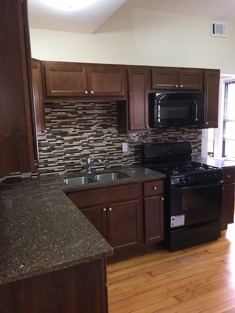 a kitchen with a sink and a stove and a microwave