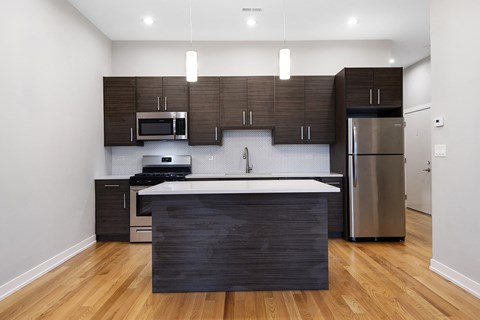 a modern kitchen with stainless steel appliances and wooden cabinets