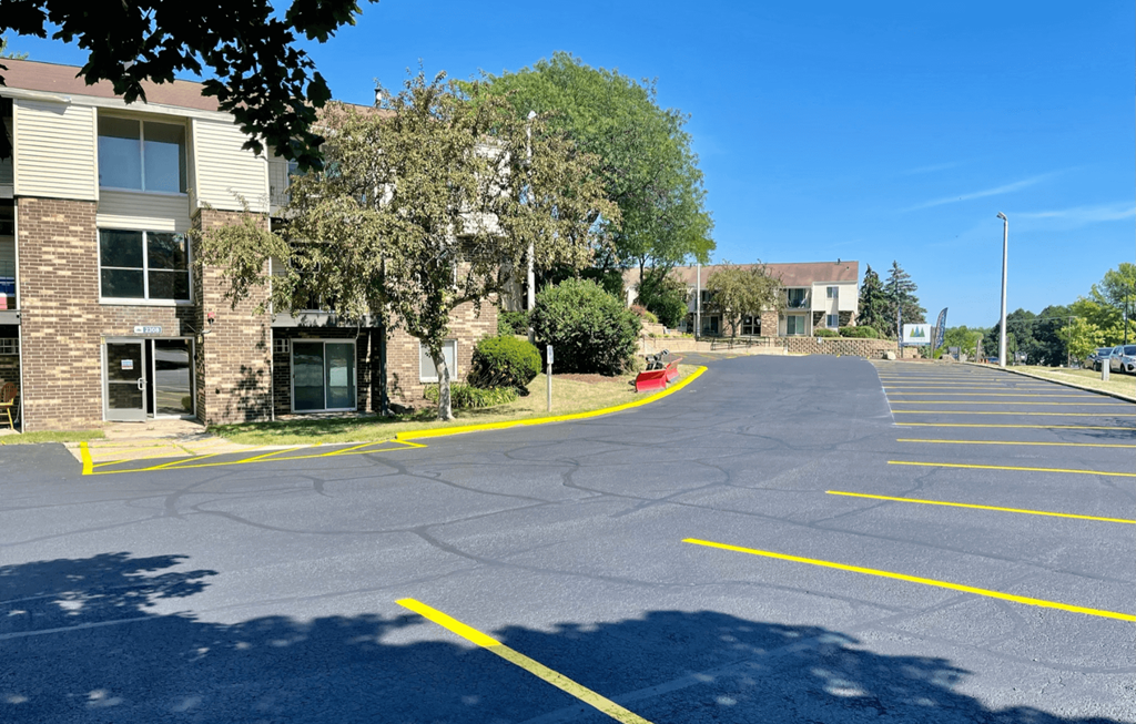 an empty parking lot in front of an apartment building
