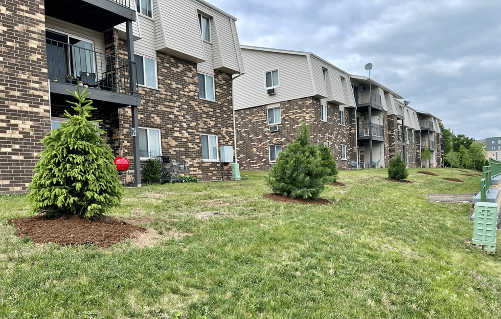 two christmas trees in front of an apartment building