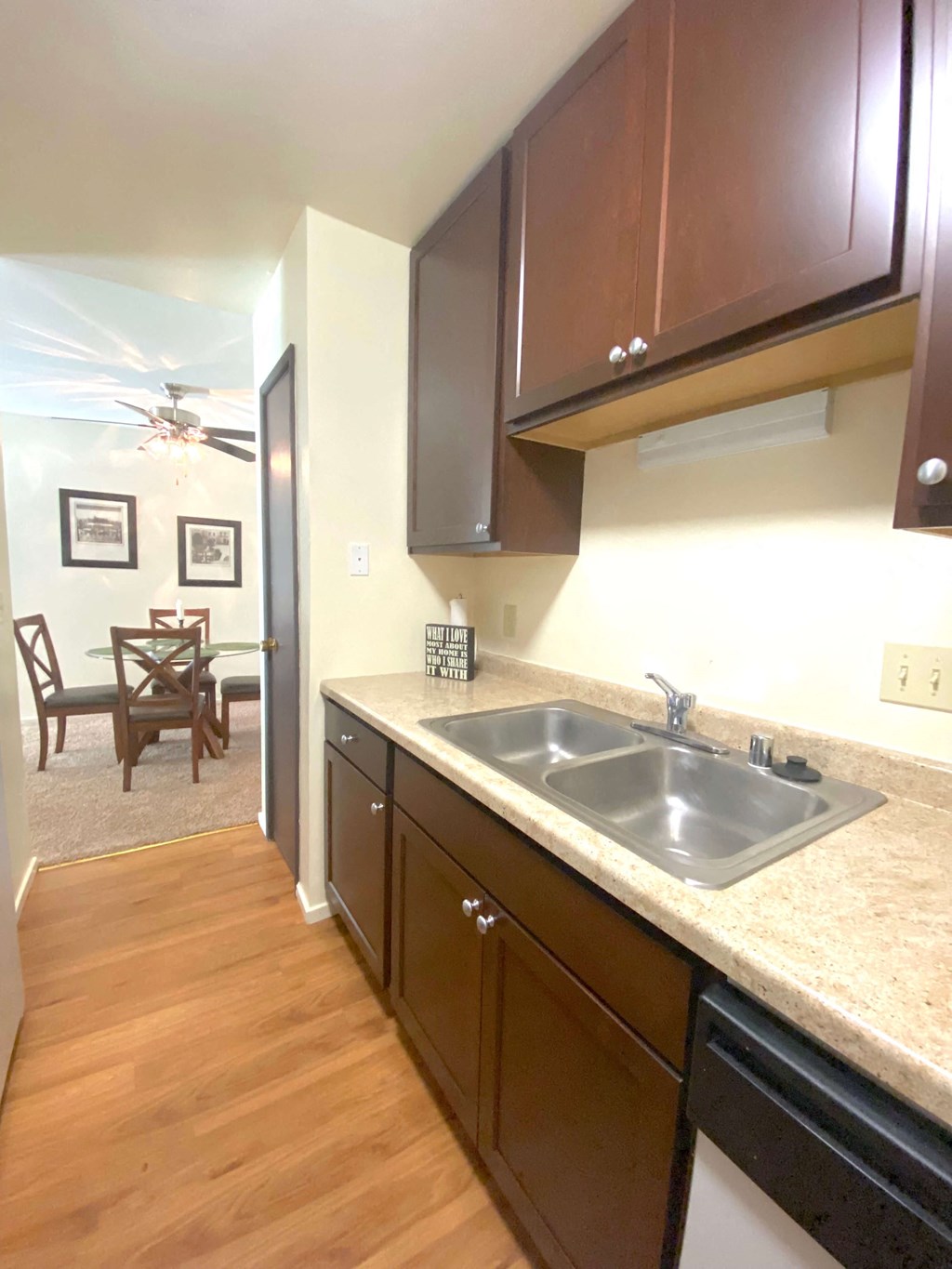 a kitchen with a sink and cabinets and a living room with a dining room