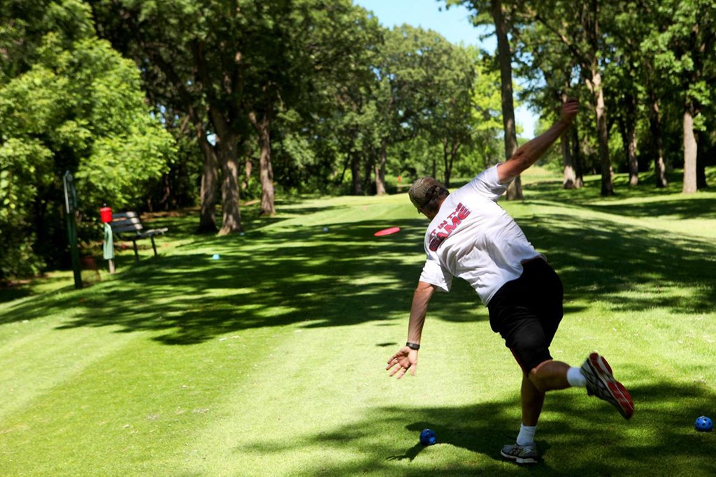 a man throwing a frisbee in a park