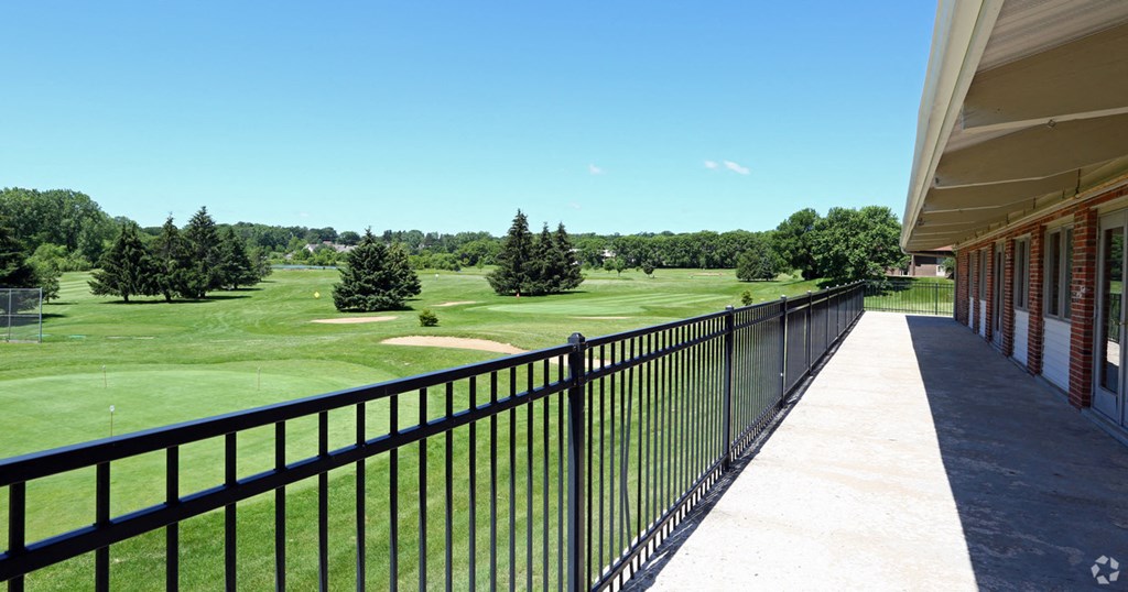 a view of a golf course from the balcony of a building