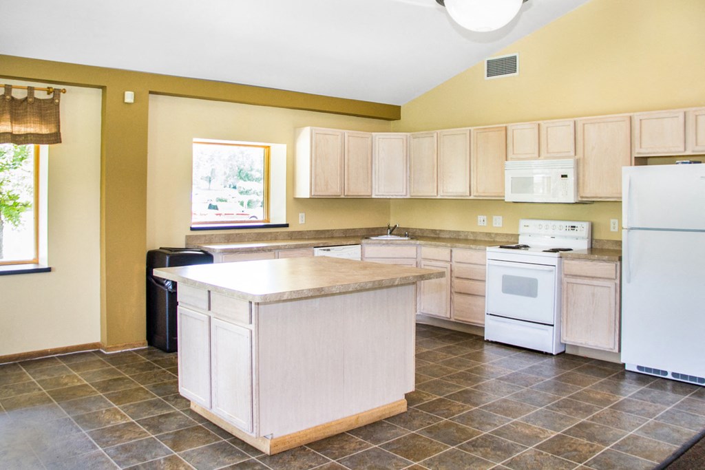 a kitchen with white appliances and wooden cabinets