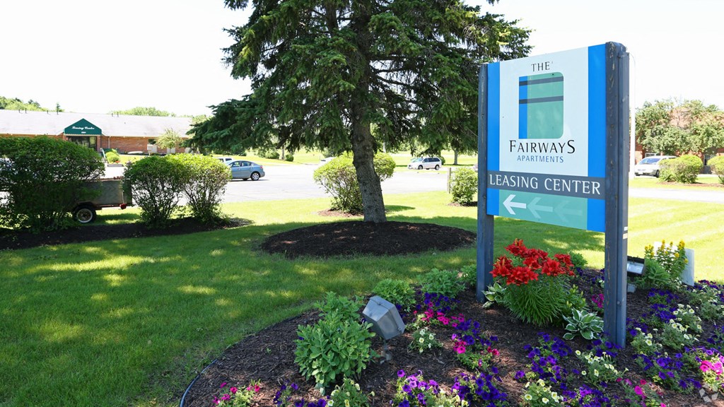 a sign for the farmers easing center in front of a garden