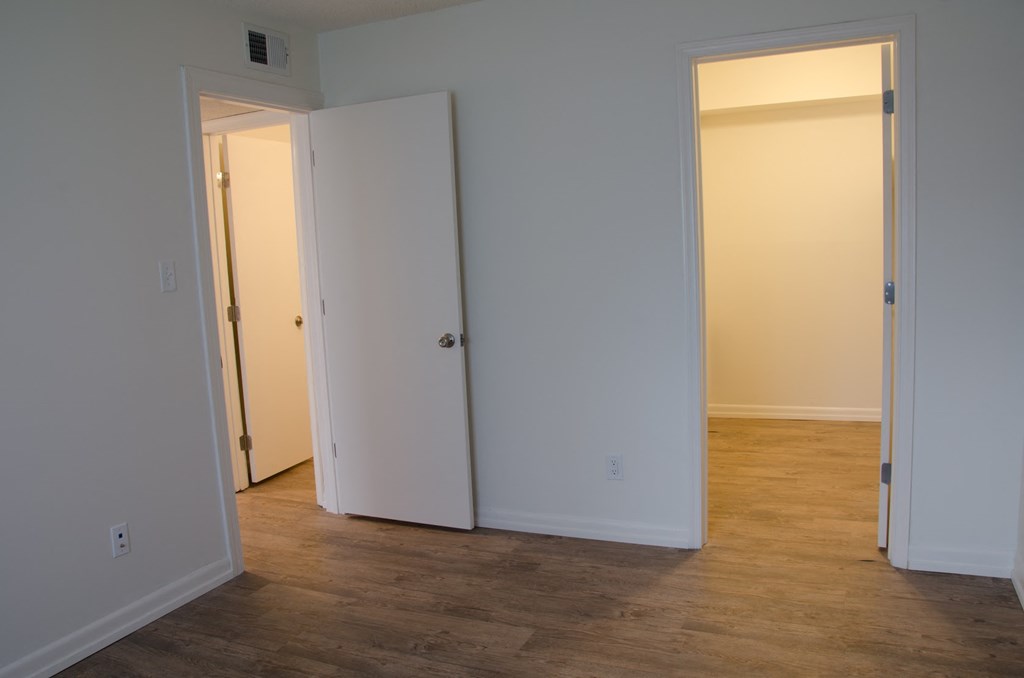 a bedroom with a door open to a hallway and a closet