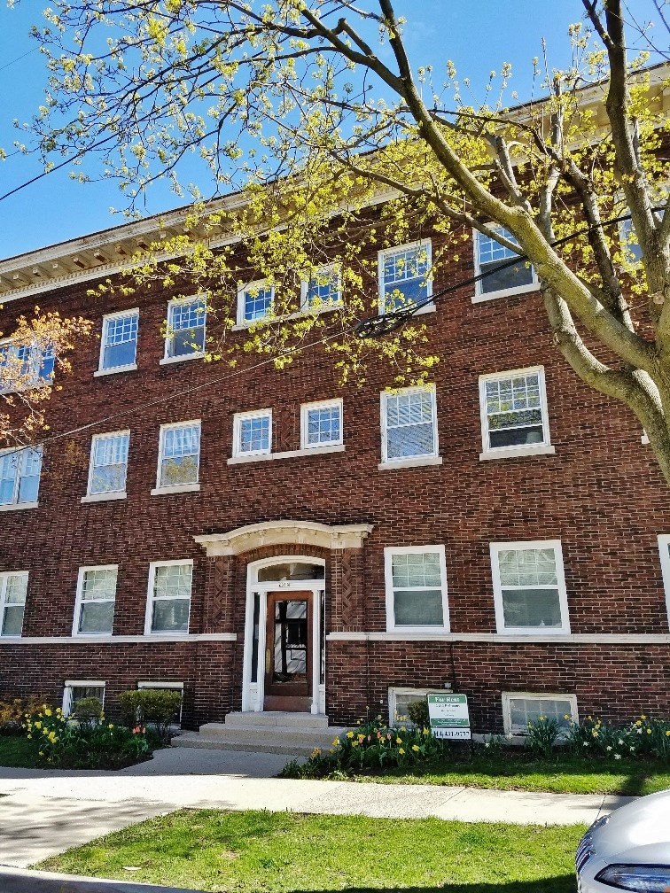 a red brick building with a tree in front of it