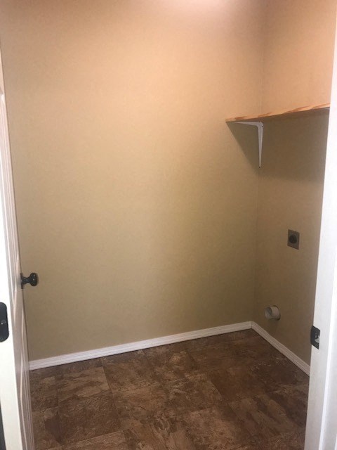 A small room with a door and a shelf on the wall.