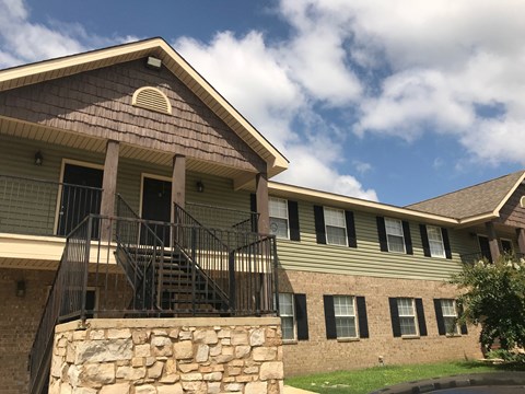 A house with a stone wall and a balcony.