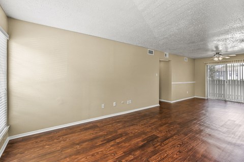 the spacious living room with wood flooring and a large window