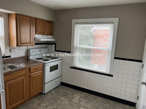 A kitchen with a white oven and sink.