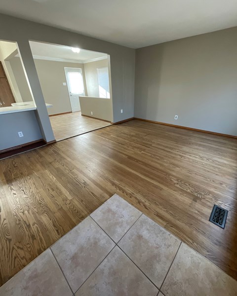 the living room and dining room of a new home with wood flooring