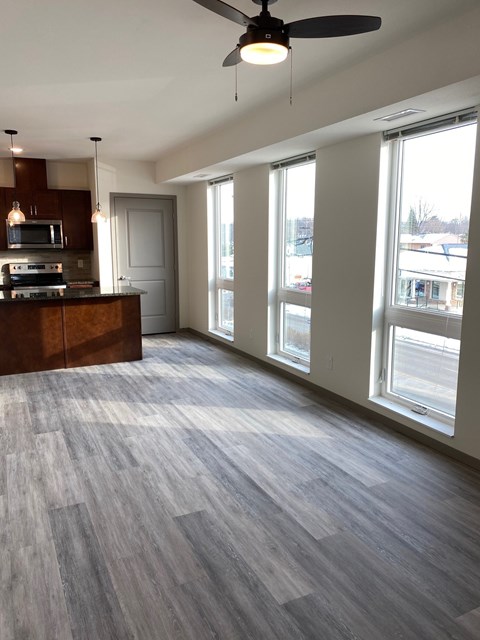 A spacious room with a wood floor and a ceiling fan.