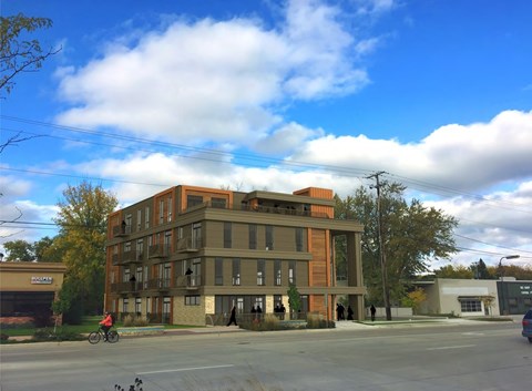 A person riding a bicycle in front of a large building.