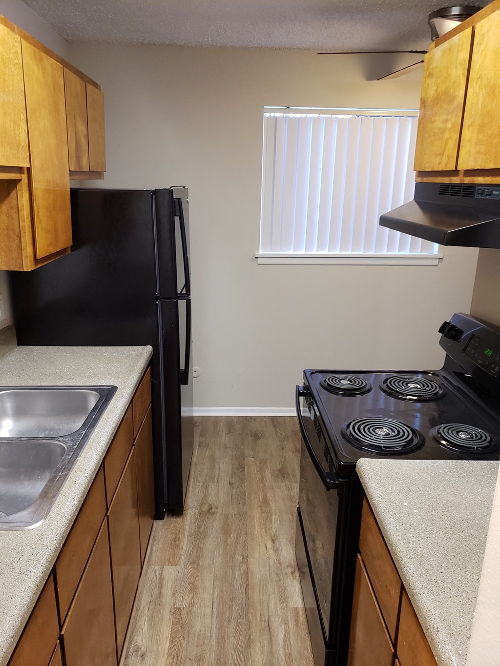 an empty kitchen with a stove refrigerator and sink