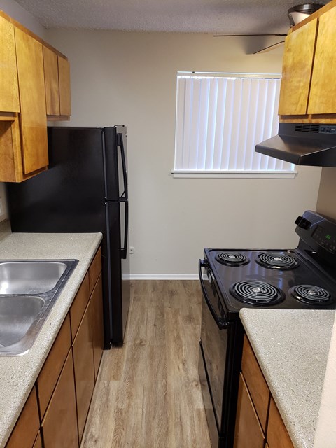 an empty kitchen with a stove refrigerator and sink