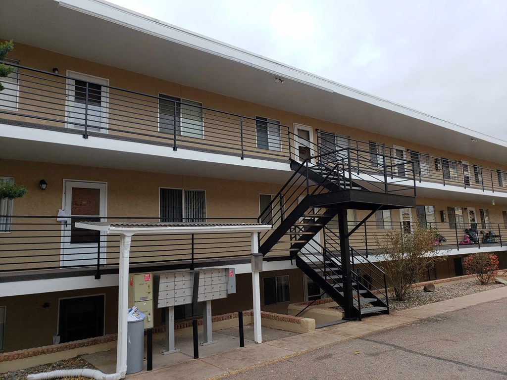 the outside of an apartment building with a black staircase