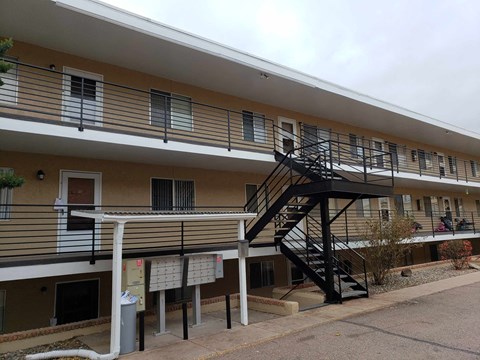 the outside of an apartment building with a black staircase