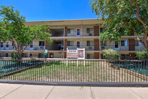 Apartment complex with a pool and a sign that says 1010 Delaware.