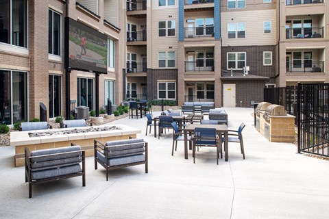 an outdoor patio with tables and chairs at an apartment complex