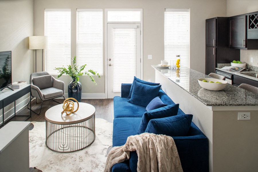 a living room with a blue couch and a kitchen